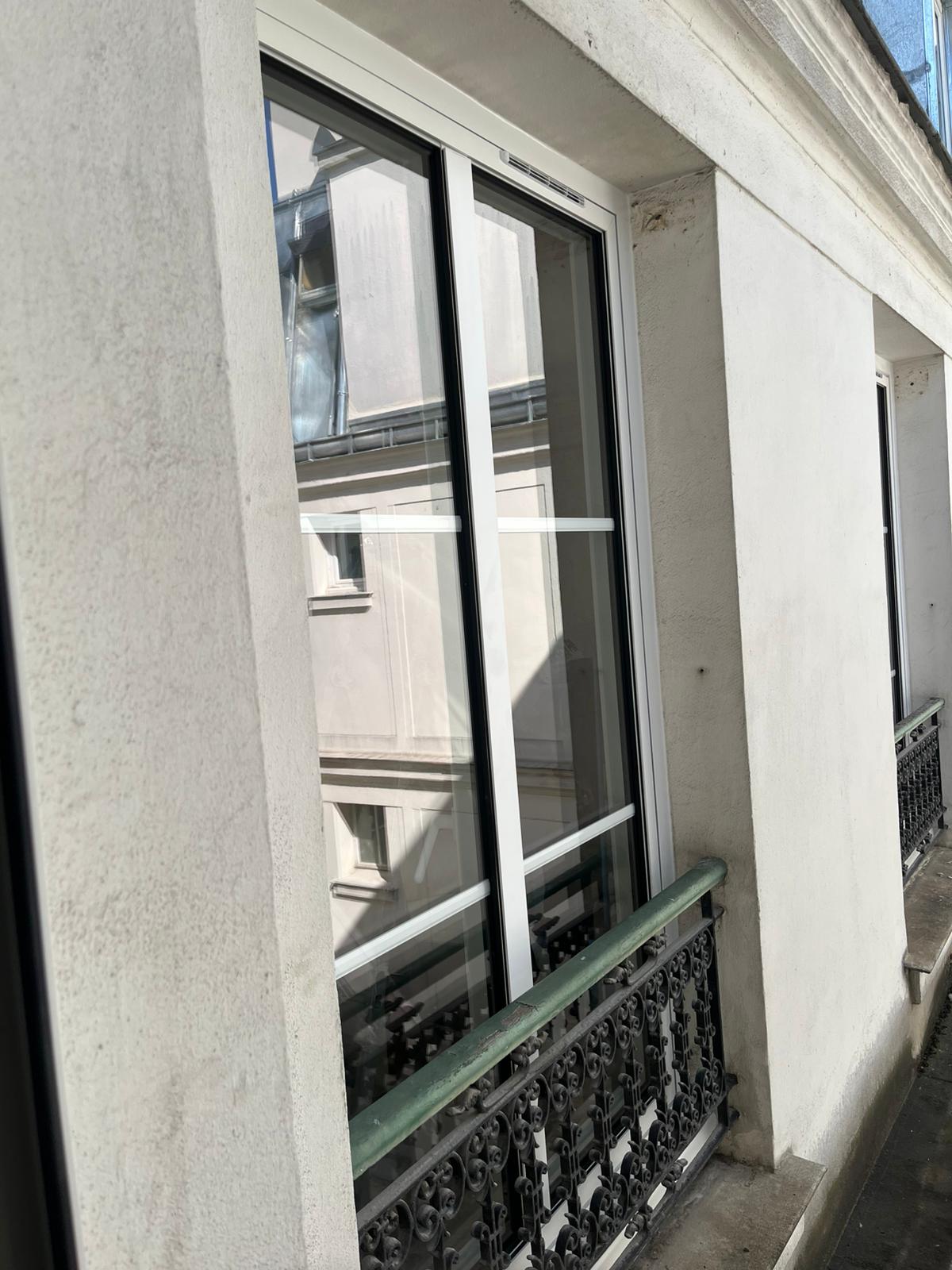 Fenêtre coulissante en aluminium noir avec grande baie vitrée offrant une vue panoramique